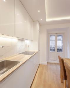 een keuken met witte kasten en een houten vloer bij Luxury flat Chamberi IV in Madrid