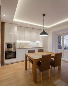 een keuken met een houten eettafel en stoelen bij Luxury flat Chamberi IV in Madrid