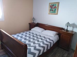 1 dormitorio con 1 cama con edredón blanco y negro en Gite de vacances Residence La Babaute LES ROUSSES, en Les Rousses