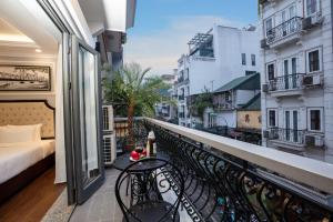 a balcony with a bed and a view of a city at Babylon Premium Hotel & Spa in Hanoi