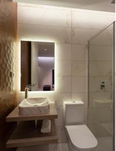 een badkamer met een toilet, een wastafel en een spiegel bij Luxury flat Chamberi IV in Madrid