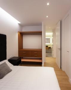 een slaapkamer met een wit bed en een flatscreen-tv bij Luxury flat Chamberi IV in Madrid