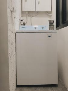 a white refrigerator in a kitchen with white cabinets at PlainStay Hostel in Taipei