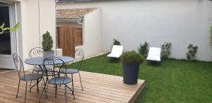 a patio with a table and chairs on a deck at clos des mûriers in Beaune