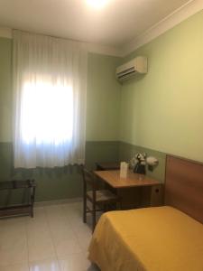 ein Schlafzimmer mit einem Tisch, einem Bett und einem Fenster in der Unterkunft Yellow Park Hotel in Forchia + 14 Fotos