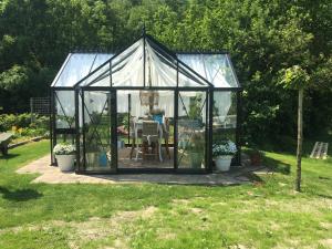 a greenhouse with a table in a garden at 't Gorsje in Goedereede