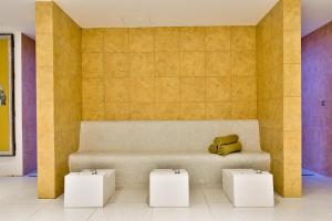 a bench in a room with two white stool at HOLM Boutique & SPA - IK Collection in St. Julianʼs