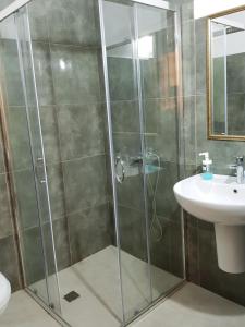 y baño con ducha y lavamanos. en Hotel Kurtabeg en Shkodër