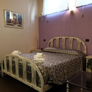 a bedroom with a bed and a purple wall at B&B Il Rustico in Turate