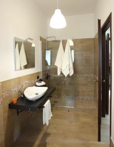 bagno con lavandino e doccia di Rooms Project B&B a Capoterra