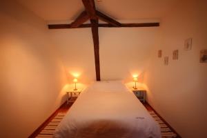 Sainte-Foy-de-LongasにあるLe Domaine des Farguesのベッドルーム1室(大型ベッド1台、2つの照明付)