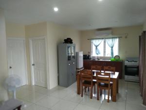 a kitchen with a table and chairs and a refrigerator at Kuinis Guesthouse in Apia
