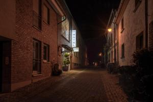 eine leere Straße in der Nacht mit einem beleuchteten Gebäude in der Unterkunft Hotel Garni Regent in Euskirchen