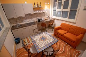 a kitchen with an orange couch and a table and chairs at Teatro sullo Stretto in Messina