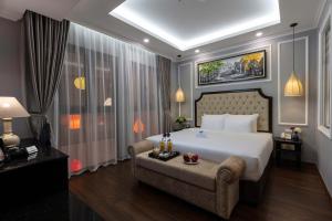 1 dormitorio con 1 cama blanca grande y 1 sofá en Babylon Premium Hotel & Spa, en Hanói