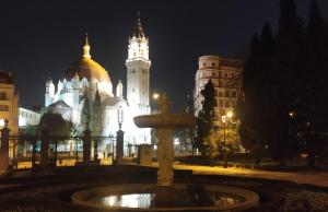 una fuente frente a un edificio por la noche en Mirador Madrid, en Madrid