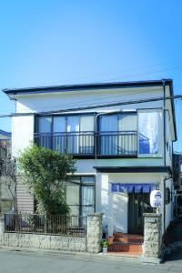 a large white building with a balcony on a street at HISAYO'S INN in Tokyo