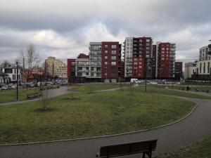 a park with a bench in a city with tall buildings at Mario Studio in Vilnius