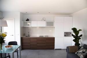 a kitchen with white cabinets and a table in a room at Balcón del Albayzín in Salobreña