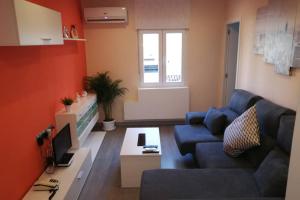 a living room with a blue couch and a table at Apartamento Centrico , Wifi + Desayuno in Logroño