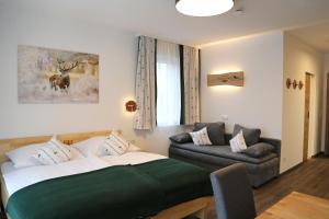 een woonkamer met een bed en een bank bij Apartments Schmiedgut in Haus im Ennstal