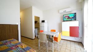 a dining room with a table and chairs and a tv at Appartamento Aurora in Lido degli Estensi