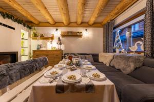 a dining room with a long table and a couch at Chaty Anety Domki Całoroczne in Solina