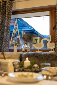 a dining room table with a candle and a window at Chaty Anety Domki Całoroczne in Solina