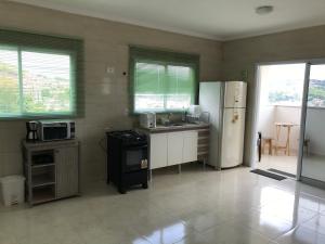 a kitchen with a refrigerator and a stove top oven at Apto 3 quartos com espaço gourmet e vista Panorâmica in Poços de Caldas