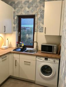 a kitchen with a sink and a washing machine at Gemütliches Ferienhaus hinterm Deich in Nordstrand