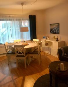 a living room with a dining room table and chairs at Gemütliches Ferienhaus hinterm Deich in Nordstrand