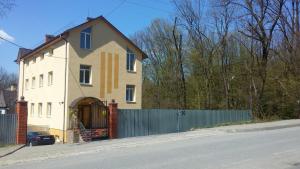 ein Haus mit einem Zaun vor einer Straße in der Unterkunft Apartments near Dolphinarium in Truskawez