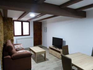 sala de estar con sofá, TV y mesa en casa CAZORLA C DEL VALLE, en Cazorla