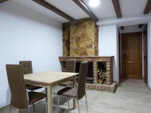 una sala da pranzo con tavolo e sedie e un camino di casa CAZORLA C DEL VALLE a Cazorla