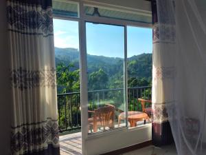a room with a balcony with a view of the mountains at Heavens Seven in Ella