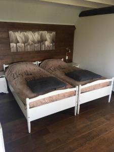 2 camas individuales en un dormitorio con paredes de madera en t Appelstekje, en Appeltern