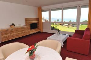 a living room with two tables and a red couch at Hotel Sonnenhof in Eichenberg