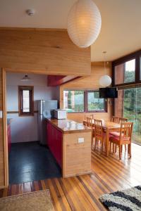 a kitchen and dining room with a table and chairs at Cabañas Tungulú in Puerto Montt