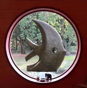 a round window with a cat and a whale head at Chambre d’Hôtes Neptune Wood in Arzens