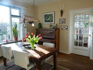 a dining room with a wooden table with flowers on it at B&B de Pastory in Warns