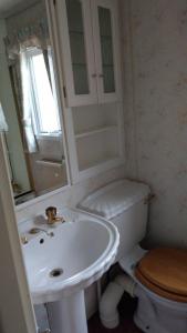 a white bathroom with a sink and a toilet at The Boat House Guesthouse in Boat of Garten