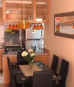una cocina con una mesa con un jarrón de flores. en Departamento Libertad, en La Serena