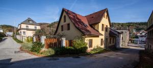 a yellow house with a brown roof on a street at VegZion - vegan B&B in Svoboda nad Úpou