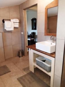 een badkamer met een witte wastafel en een spiegel bij De Turfstaeker in Ospel