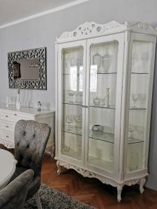 a white cabinet with glass shelves in a living room at Apartments Popovic in Kotor