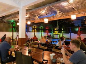 Poolside Villa في بنوم بنه: مجموعة من الناس يجلسون على طاولة في مطعم