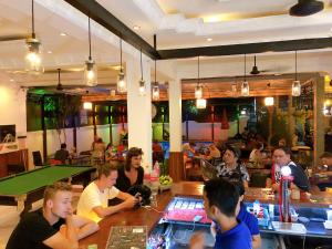 um grupo de pessoas sentadas num bar em Poolside Villa em Phnom Penh