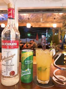 eine Flasche Alkohol und zwei Getränke auf dem Tisch in der Unterkunft Poolside Villa in Phnom Penh