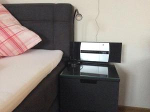 a bedroom with a bed and a night stand with a microwave at Fernblick in Zweibrücken