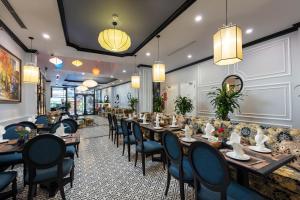 uma sala de jantar com mesas longas e cadeiras em Babylon Premium Hotel & Spa em Hanói
